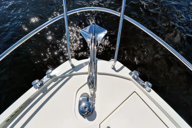 Joan's Rondevous Yacht Photos Pics Bow view of 2025 Absolute 52 FLY yacht with gleaming chrome details on water.