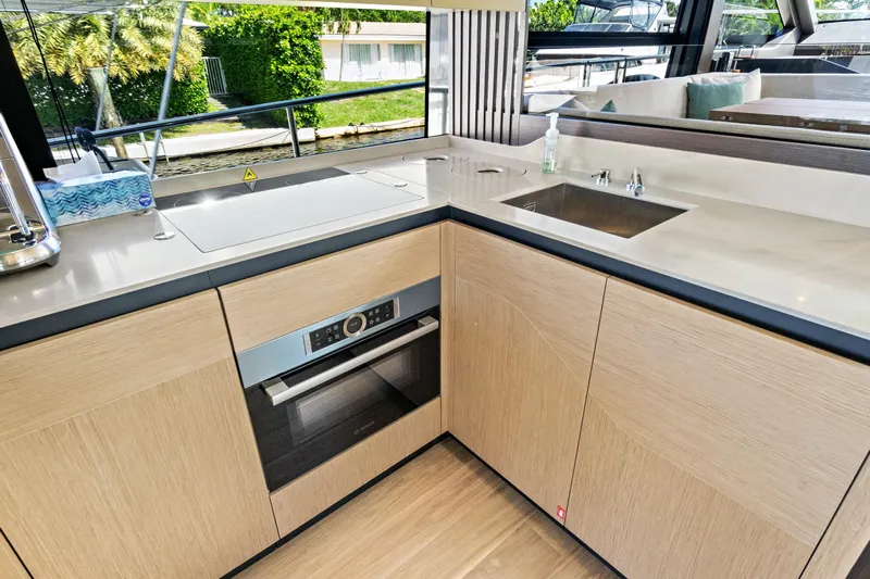 Joan's Rondevous Yacht Photos Pics Modern kitchen interior on 2025 Absolute 52 FLY yacht, featuring sleek design and appliances.