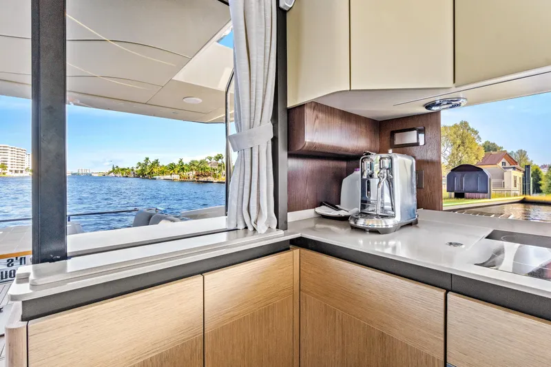 Joan's Rondevous Yacht Photos Pics Modern kitchen interior on Absolute 52 FLY yacht, featuring sleek cabinetry and scenic water views.