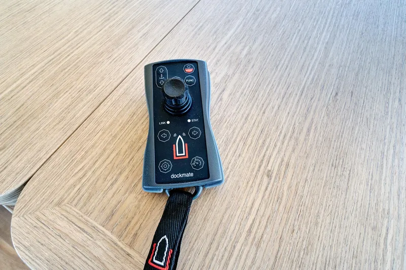 Joan's Rondevous Yacht Photos Pics Remote control for Absolute 52 FLY 2025 yacht on wooden surface.