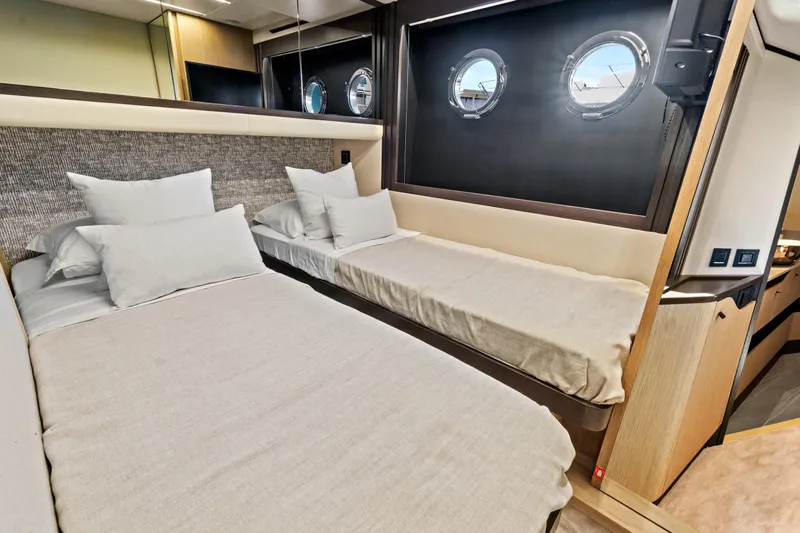 Joan's Rondevous Yacht Photos Pics Luxurious cabin interior of 2025 Absolute 52 FLY yacht with twin beds and porthole windows.