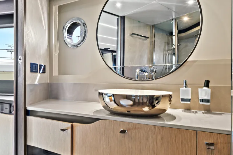 Joan's Rondevous Yacht Photos Pics Luxurious bathroom interior of 2025 Absolute 52 FLY yacht with modern fixtures and round mirror.