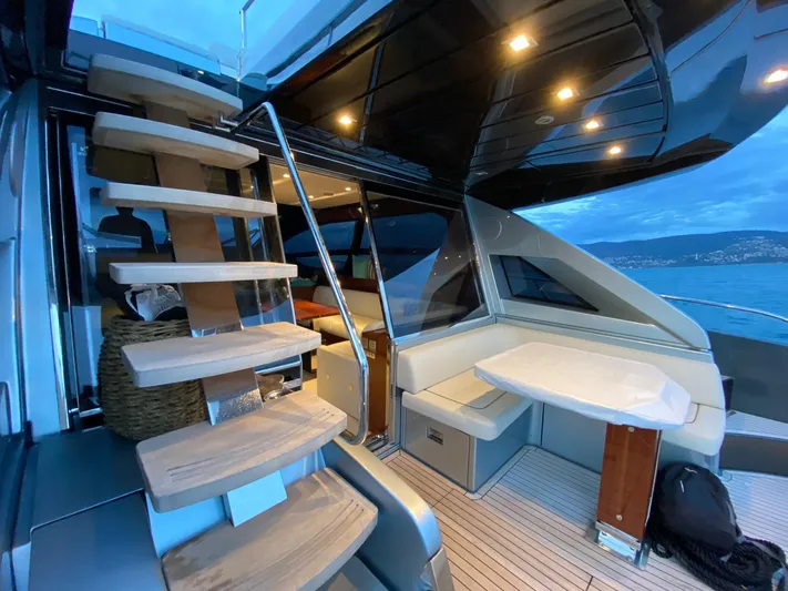  Yacht Photos Pics Luxurious interior of 2020 Riva 66' Ribelle yacht with modern staircase and seating area.