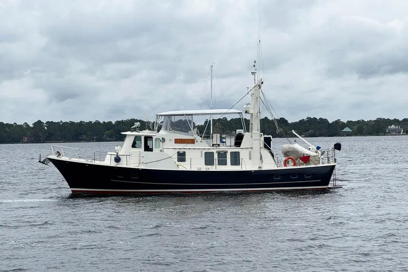  Yacht Photos Pics 1989 Seaton Trawler boat on a calm lake under cloudy skies.