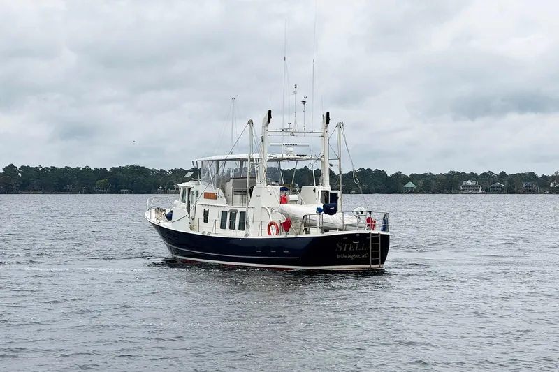  Yacht Photos Pics 1989 Seaton Trawler on calm water, overcast sky, distant shoreline.