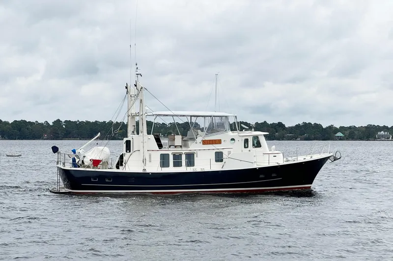  Yacht Photos Pics 1989 Seaton Trawler boat cruising on a calm lake under cloudy skies.