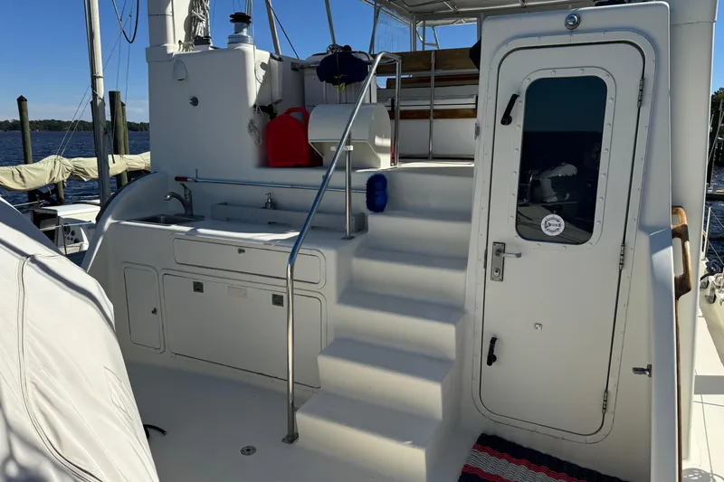  Yacht Photos Pics 1989 Seaton Trawler deck with stairs, door, and outdoor sink, docked by the water.
