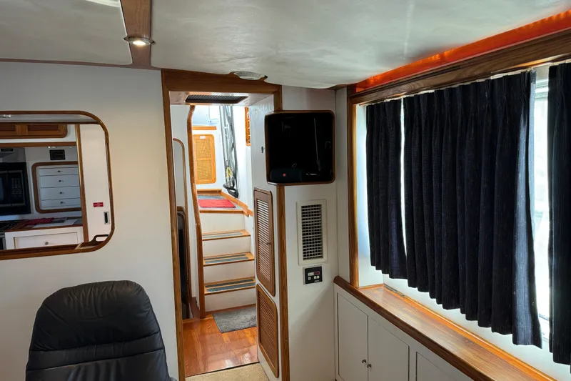  Yacht Photos Pics Interior of 1989 Seaton Trawler with wood accents and dark curtains.