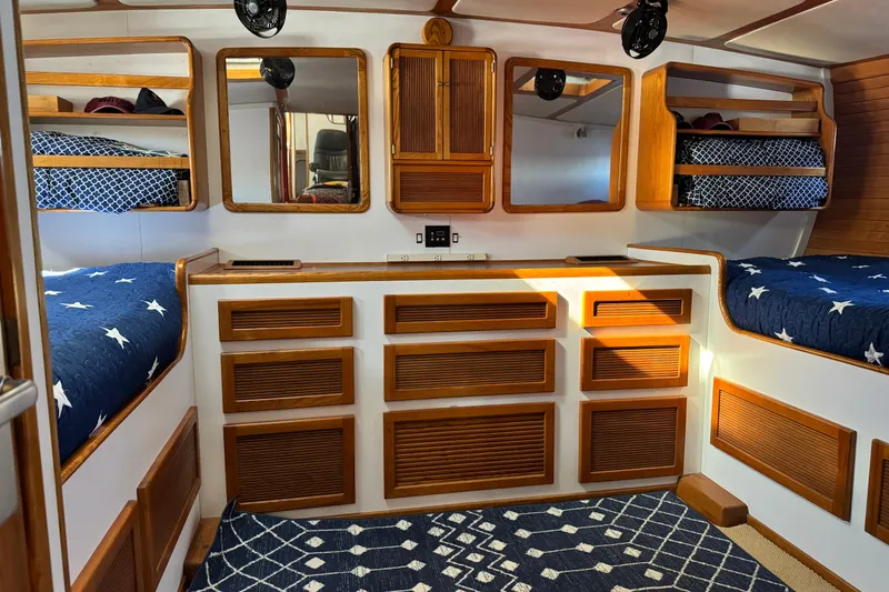  Yacht Photos Pics Cozy 1989 Seaton Trawler cabin with wooden cabinetry, star-patterned bedding, and nautical decor.