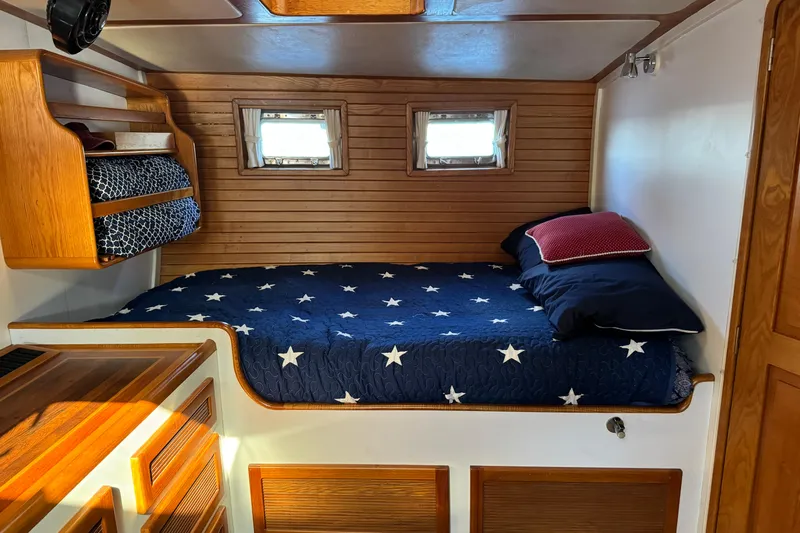  Yacht Photos Pics Cozy cabin interior of 1989 Seaton Trawler with star-patterned bedding and wooden accents.