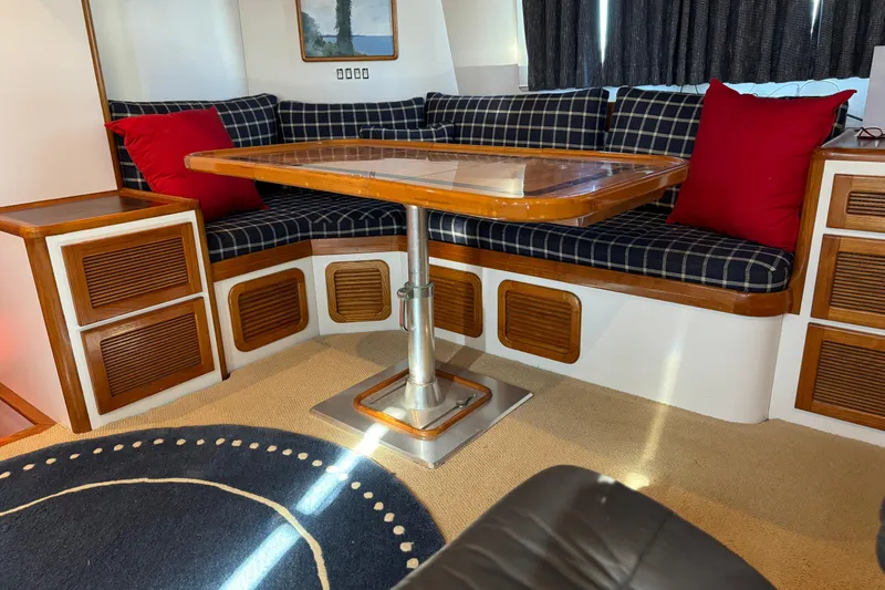  Yacht Photos Pics Interior of 1989 Seaton Trawler with plaid seating, wooden table, and red cushions.