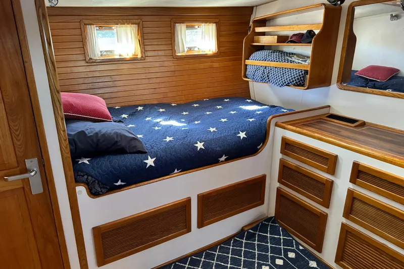  Yacht Photos Pics Cozy cabin interior of 1989 Seaton Trawler with star-patterned bedding and wooden accents.