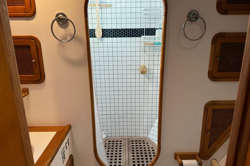  Yacht Photos Pics Bathroom interior of 1989 Seaton Trawler with tiled shower and wooden accents.