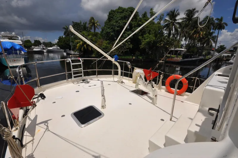  Yacht Photos Pics 1989 Seaton Trawler deck with safety equipment, docked near lush greenery and other boats.
