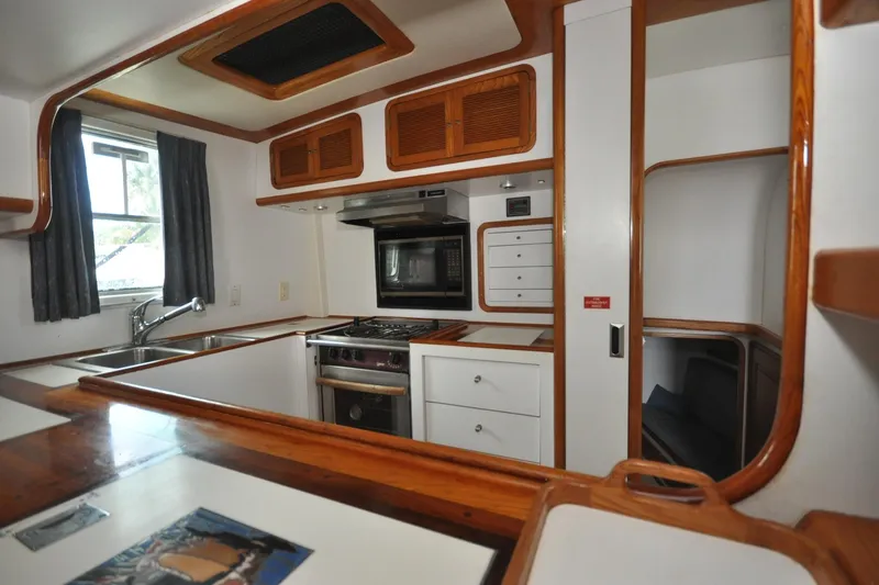  Yacht Photos Pics 1989 Seaton Trawler kitchen with wood accents, stove, and sink.