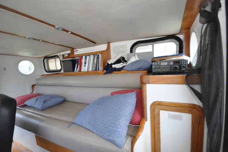  Yacht Photos Pics 1989 Seaton Trawler interior with cushioned seating, books, and radio equipment.