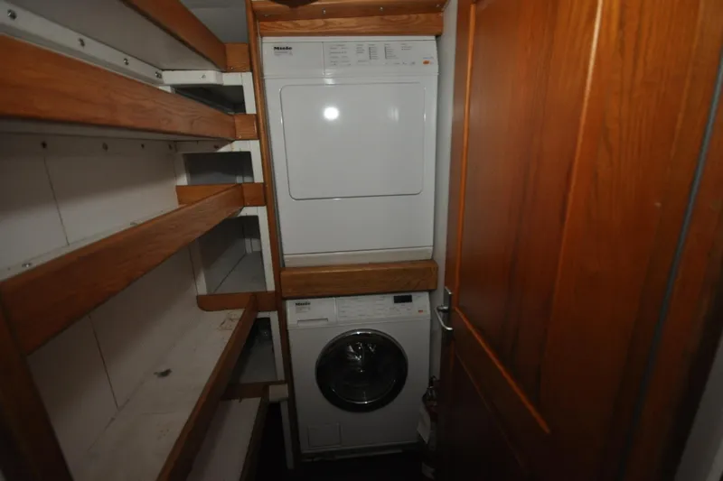 Yacht Photos Pics Laundry area in 1989 Seaton Trawler with washer, dryer, and wooden shelving.