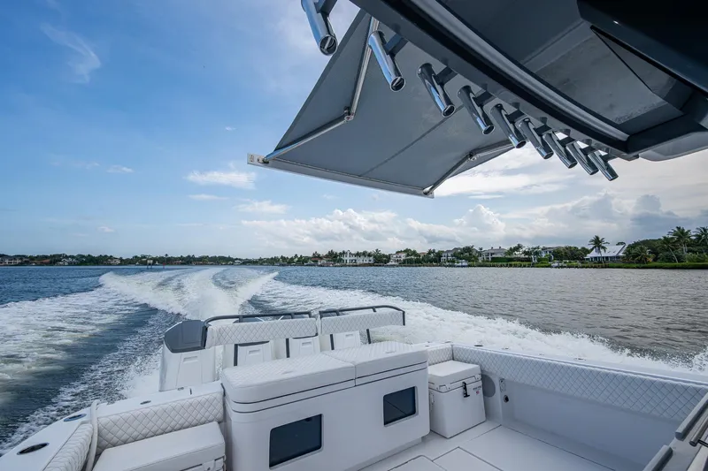 Yacht Photos Pics 2025 HCB 48 Campeon boat cruising on a scenic waterway under a clear blue sky.