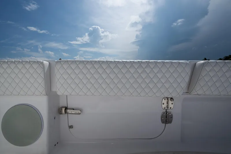  Yacht Photos Pics 2025 HCB 48 Campeon boat interior with quilted upholstery and speaker under a cloudy sky.