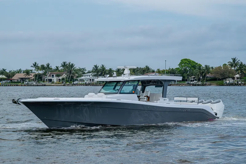  Yacht Photos Pics 2025 HCB 48 Campeon boat cruising on a calm waterway with scenic background.