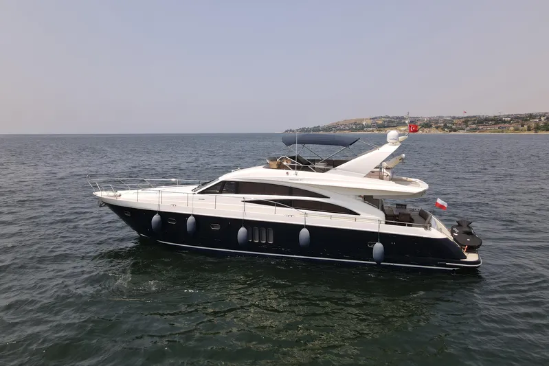  Yacht Photos Pics 2008 Princess 67 Flybridge yacht cruising on calm waters near a coastal city.