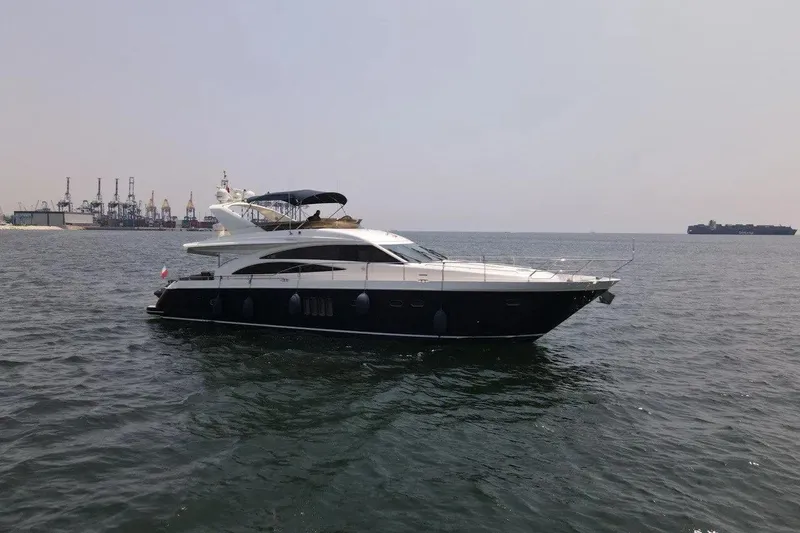  Yacht Photos Pics 2008 Princess 67 Flybridge yacht cruising on open water near industrial port.