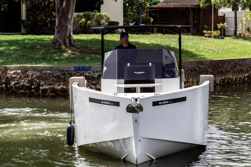 Yacht Photos Pics 2024 De Antonio Yachts D28 Open cruising on a calm waterway, surrounded by greenery.