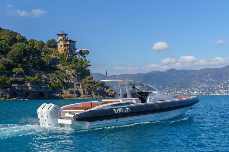  Yacht Photos Pics 2026 Pirelli 50 boat cruising near scenic coastal landscape with historic architecture.