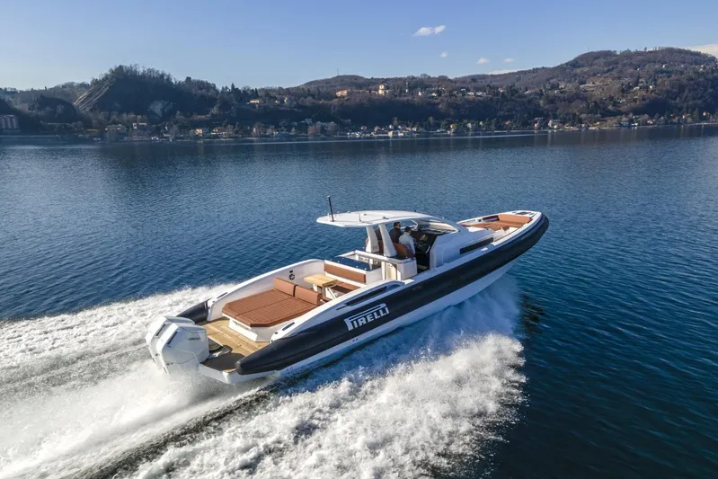  Yacht Photos Pics 2026 Pirelli 50 boat cruising on a scenic lake with hills in the background.