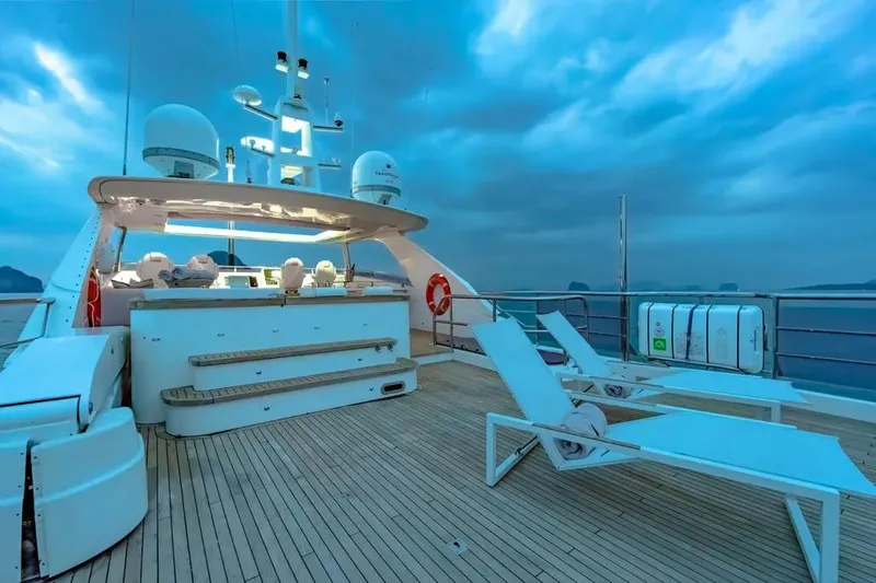 Blue Moon Yacht Photos Pics Luxurious 2013 Princess M Class 32M yacht deck with lounge chairs and bar at sunset.