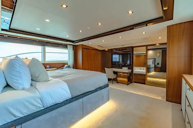 Blue Moon Yacht Photos Pics Luxurious bedroom interior on 2013 Princess M Class 32M yacht, featuring elegant wood finishes.