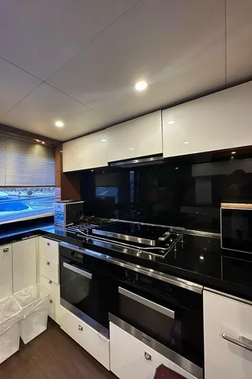 Blue Moon Yacht Photos Pics Modern kitchen interior on 2013 Princess M Class 32M yacht, featuring sleek cabinetry and appliances.