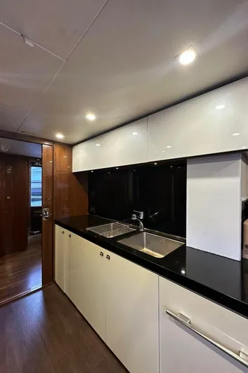 Blue Moon Yacht Photos Pics Modern kitchen interior on 2013 Princess M Class 32M yacht, featuring sleek cabinetry and lighting.
