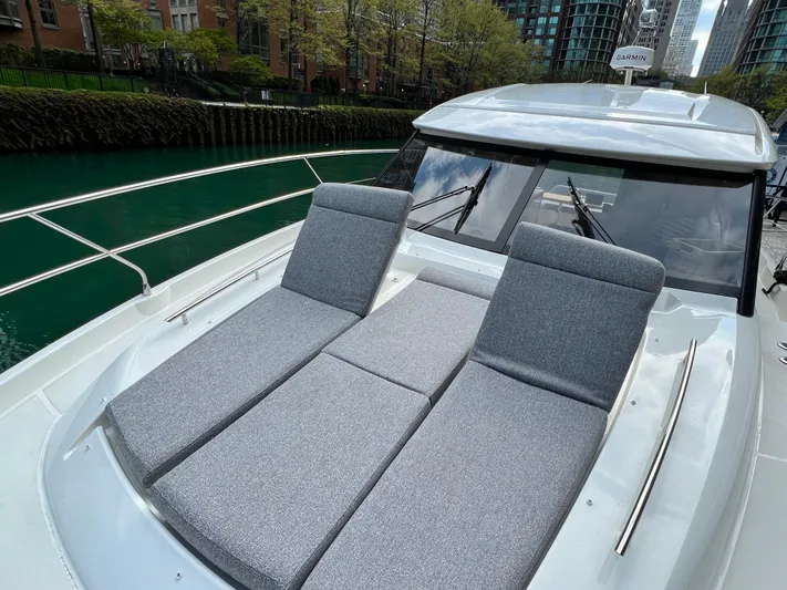  Yacht Photos Pics 2023 Prestige 420S yacht with gray sun loungers on deck, urban waterfront backdrop.