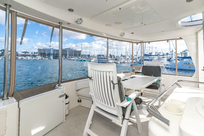 Free Spirit Yacht Photos Pics 1998 Sea Ray 420 Aft Cabin yacht interior with marina view, featuring seating and table.