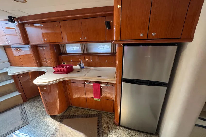 Go Girl Yacht Photos Pics Luxurious kitchen interior of 2001 Sea Ray 510 Sundancer yacht with wood cabinetry and stainless steel fridge.