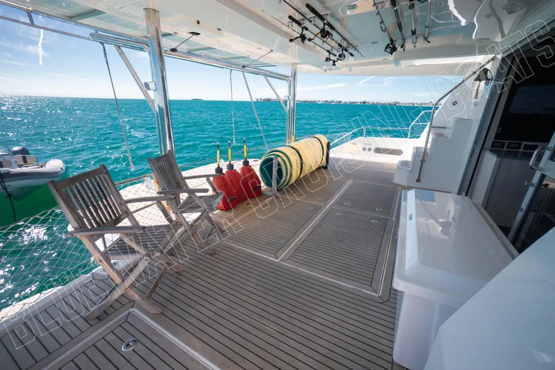 Sea Dog Yacht Photos Pics Luxurious 2020 Leopard 58 yacht deck with ocean view, featuring chairs and equipment.