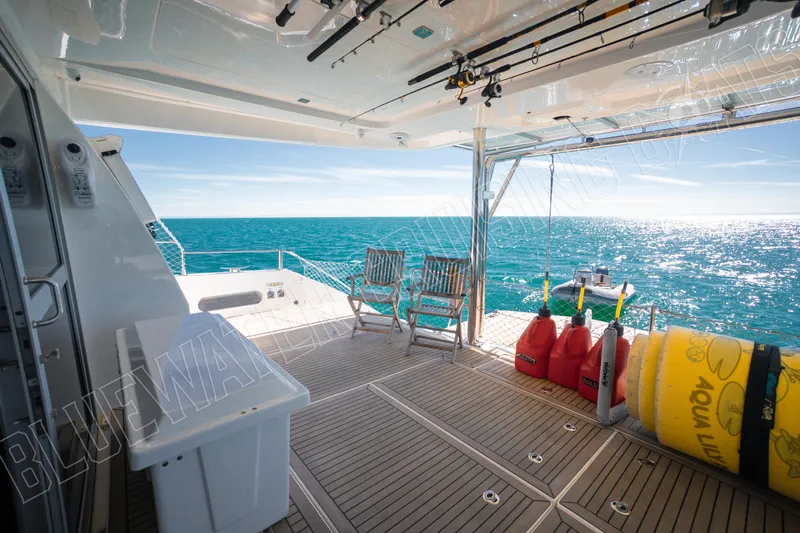 Sea Dog Yacht Photos Pics Luxurious Leopard 58 yacht deck with ocean view, fishing rods, and seating area, 2020 model.