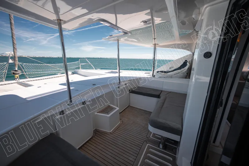 Sea Dog Yacht Photos Pics Luxurious 2020 Leopard 58 yacht deck with seating, overlooking serene ocean waters.