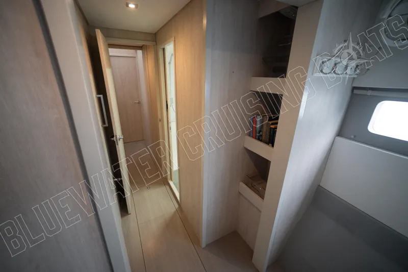 Sea Dog Yacht Photos Pics Interior hallway of 2020 Leopard 58 yacht with modern wood finish and shelving.