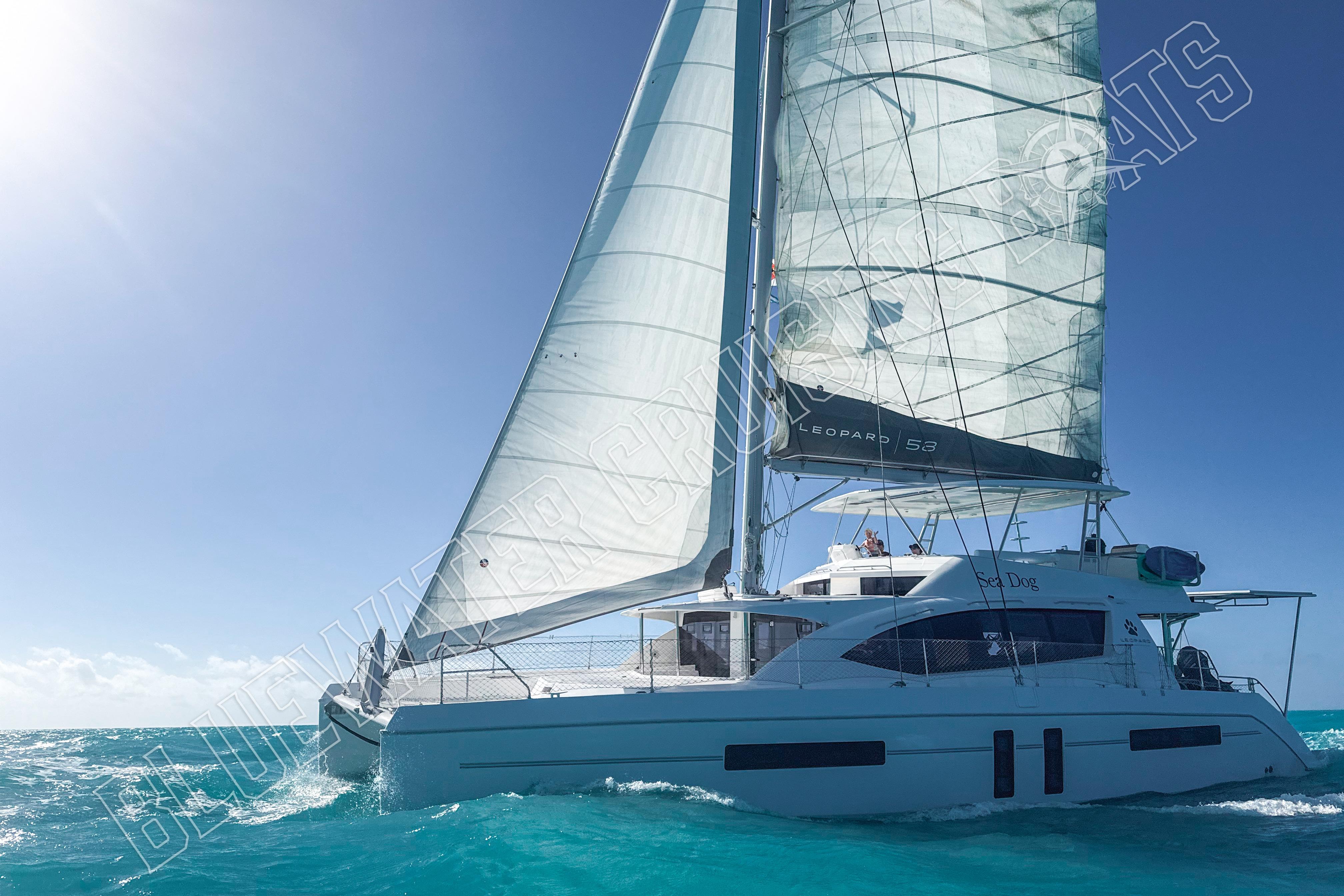 2020 Leopard 58 catamaran sailing on clear blue ocean under sunny skies.