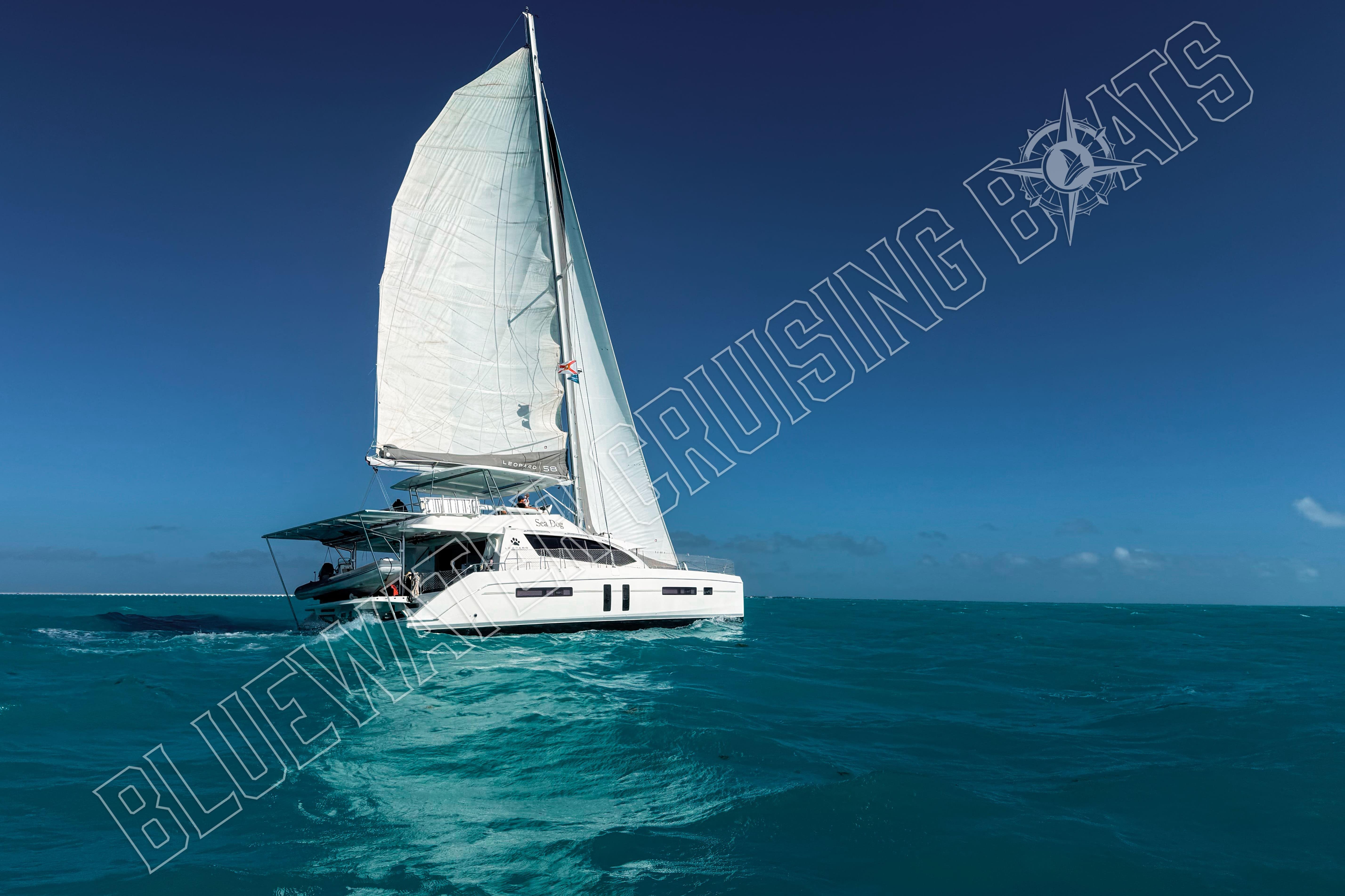 Sailing catamaran Leopard 58 cruising on turquoise waters under clear blue skies.