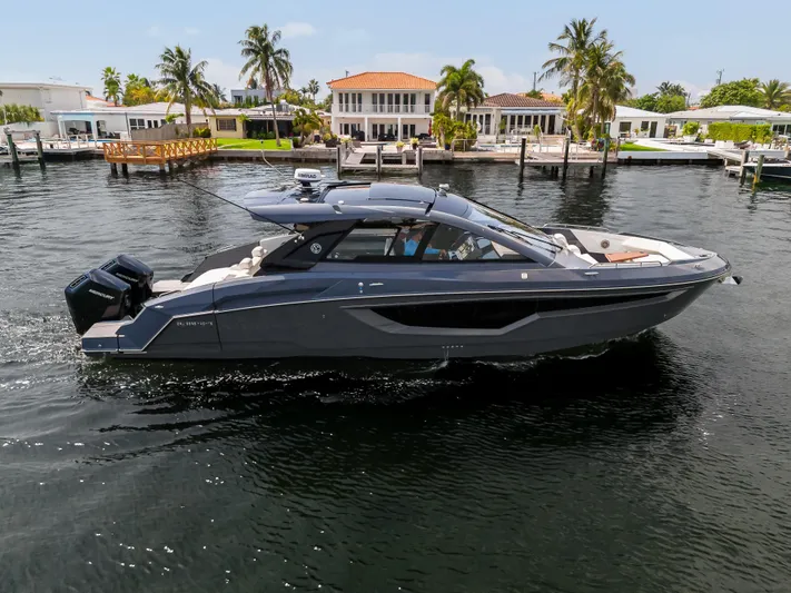  Yacht Photos Pics 2023 Cruisers Yachts 42 GLS OB on water near luxury homes and palm trees.