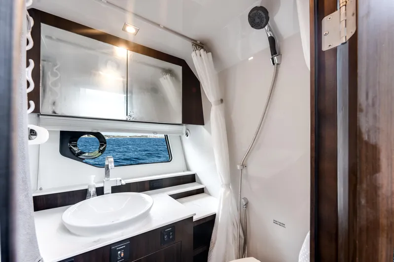  Yacht Photos Pics Luxurious bathroom interior of 2023 Cruisers Yachts 42 GLS OB with modern fixtures and ocean view.