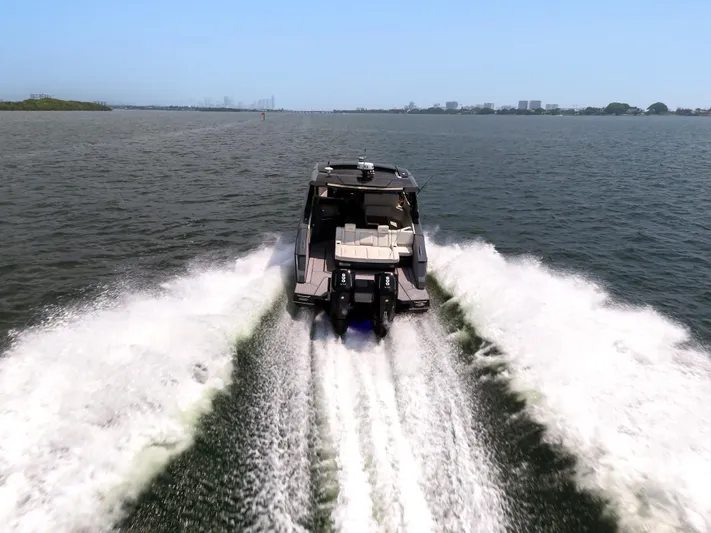  Yacht Photos Pics 2023 Cruisers Yachts 42 GLS OB speeding on open water, rear view.