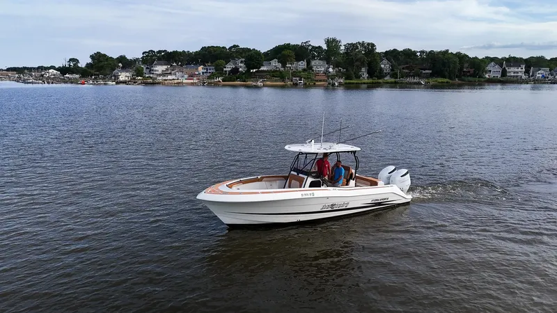  Yacht Photos Pics 2000 Hydra-Sports 2796 Vector boat cruising on a calm lake near a residential shoreline.