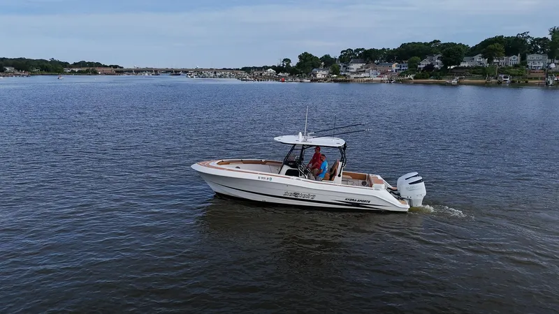  Yacht Photos Pics 2000 Hydra-Sports 2796 Vector boat cruising on a calm lake near a residential area.