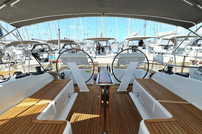 Apollo Yacht Photos Pics 2019 Hanse 458 yacht interior with dual steering wheels and wooden deck in marina.