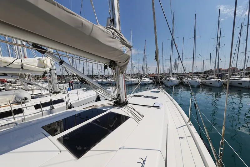 Apollo Yacht Photos Pics 2019 Hanse 458 yacht docked in a marina, surrounded by sailboats under a clear sky.