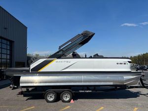 2023 Manitou Explore 22 Max Bench pontoon boat on trailer, parked outdoors.